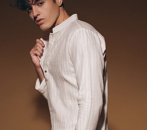 Man poses in a textured white kurta