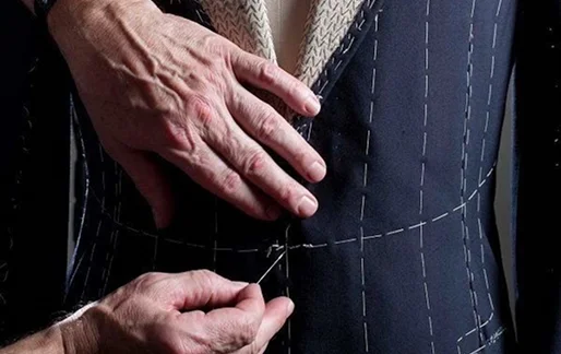 Tailor sewing a dark suit jacket
