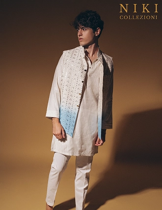 Model wearing a cream traditional attire with embroidered vest